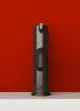 Schlichtes, graues Standventil auf weißem Sockel vor roter Wand, mit Logo von Ideal Standard sichtbar.